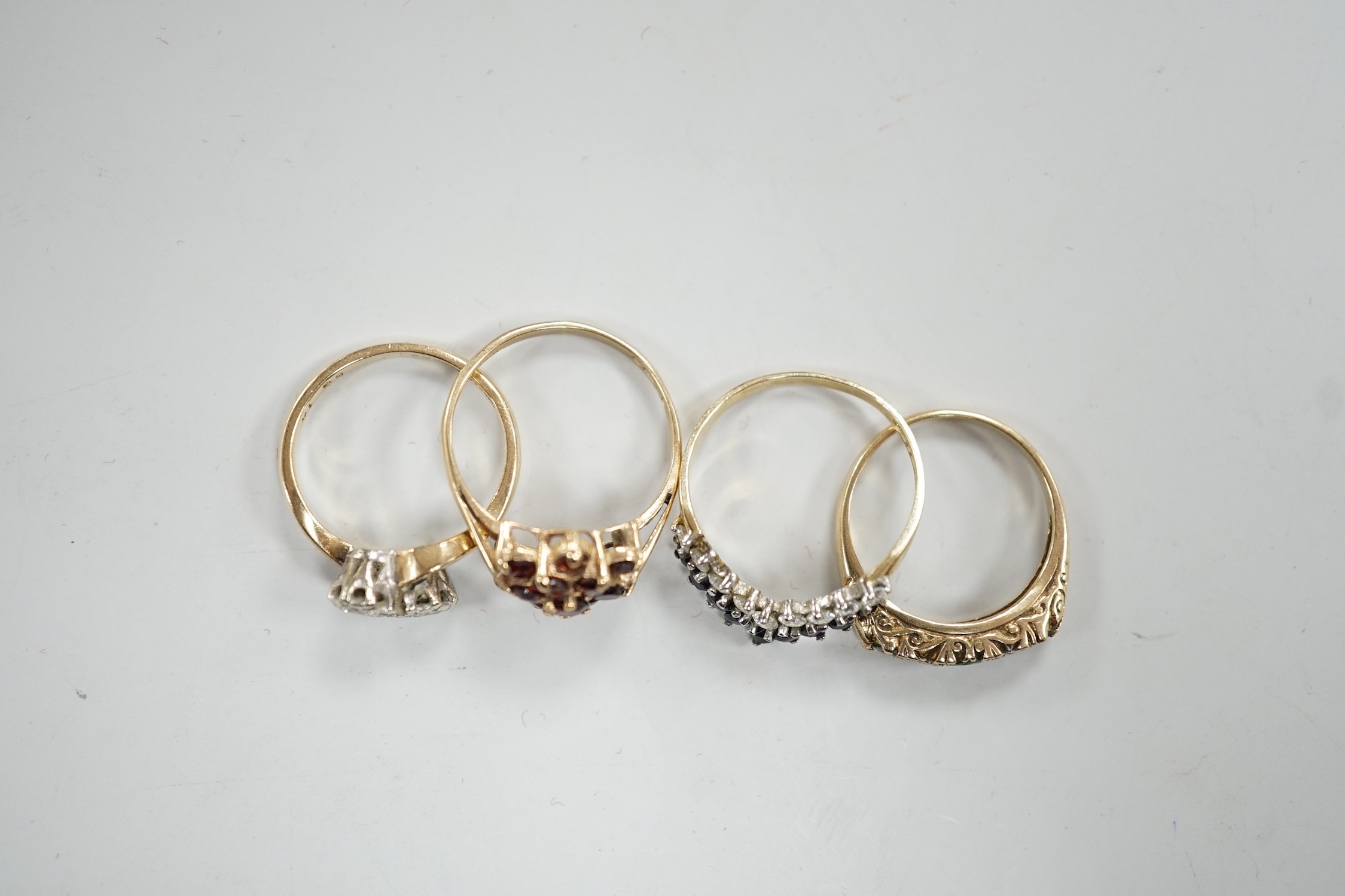 Four assorted modern 9ct gold and gem set rings, including a two stone diamond crossover, size K/L, gross 8.5 grams.